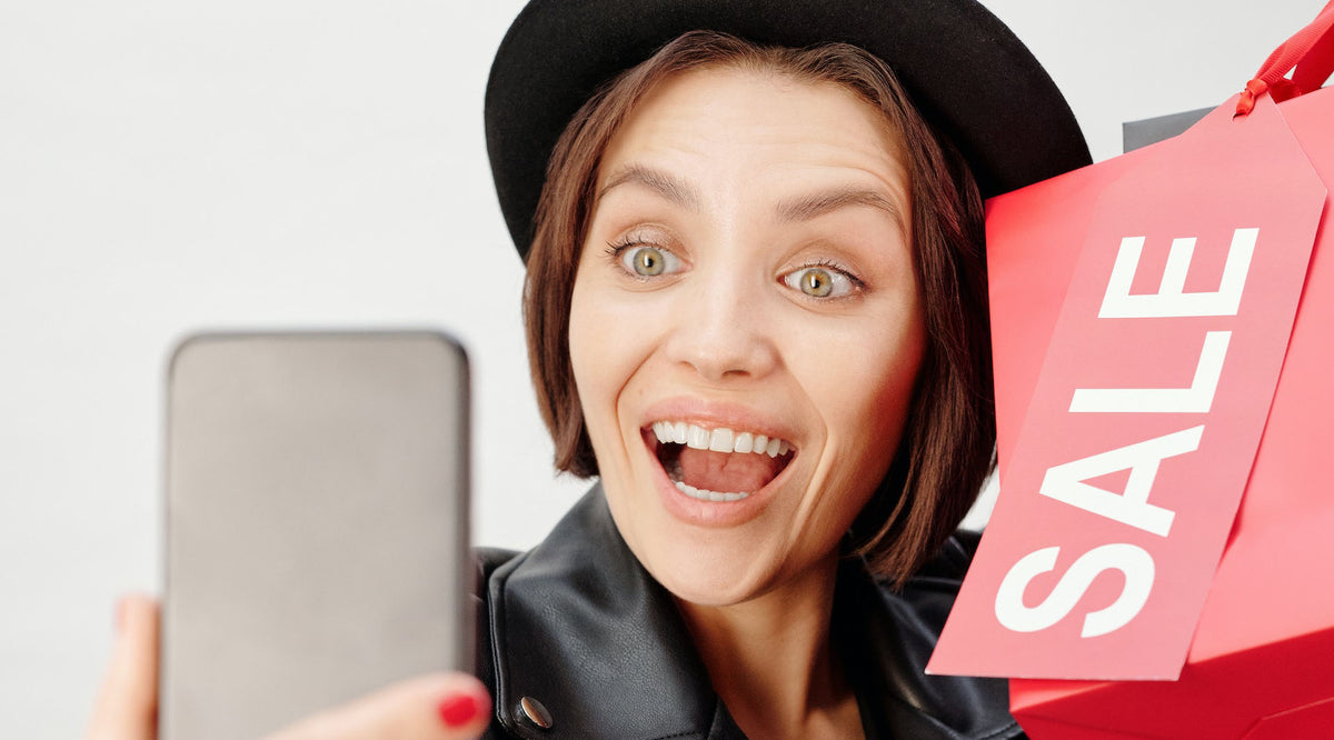 Smiling Woman in Black Leather Jacket Holding Shopping Bags