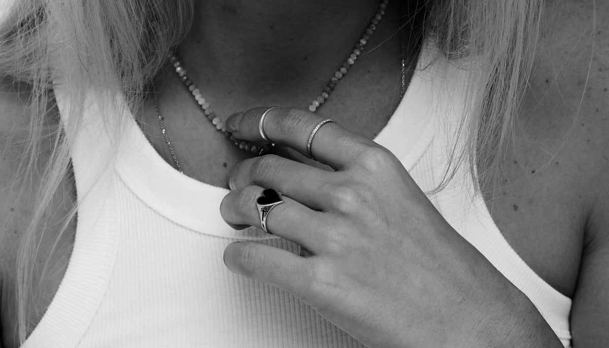 black and white photo of woman's hand wearing fashion rings