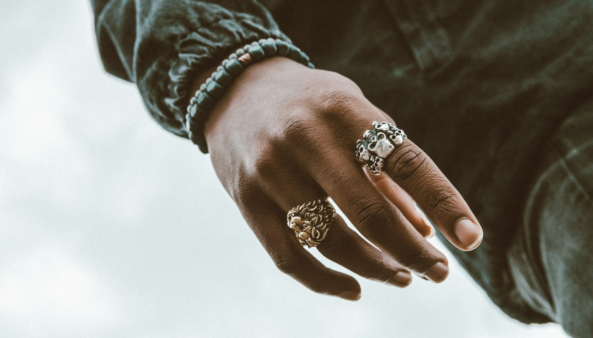 a close up of a person's hand with a ring on it