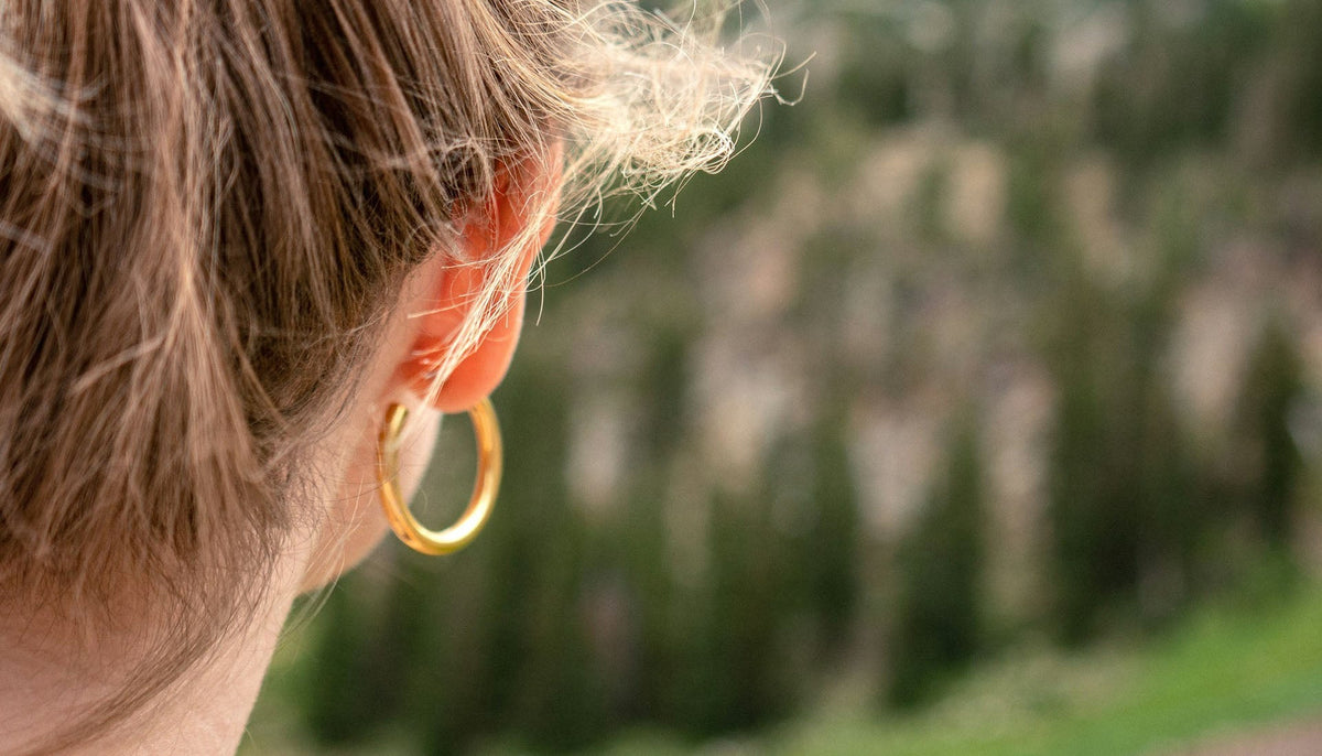 close up shot of the back of a teen's head with a ponytail and hoop earrings