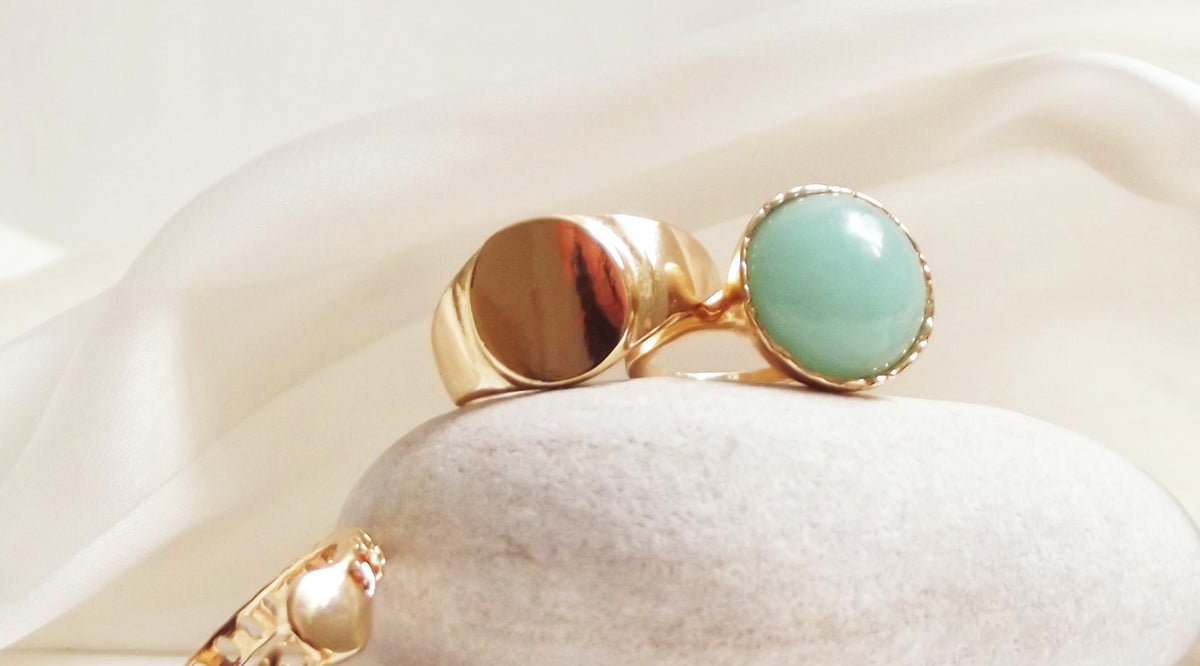 fashion rings displayed on top of a smooth gray stone