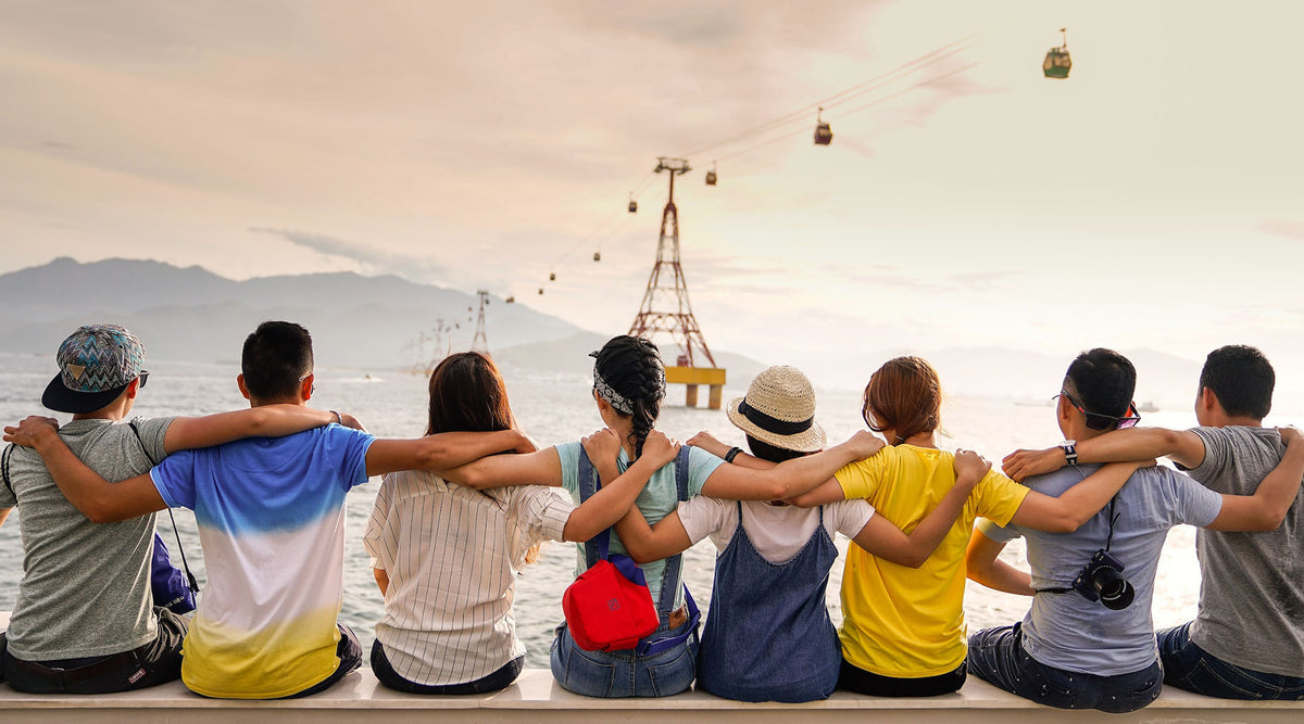 group of friends sitting on the seawall