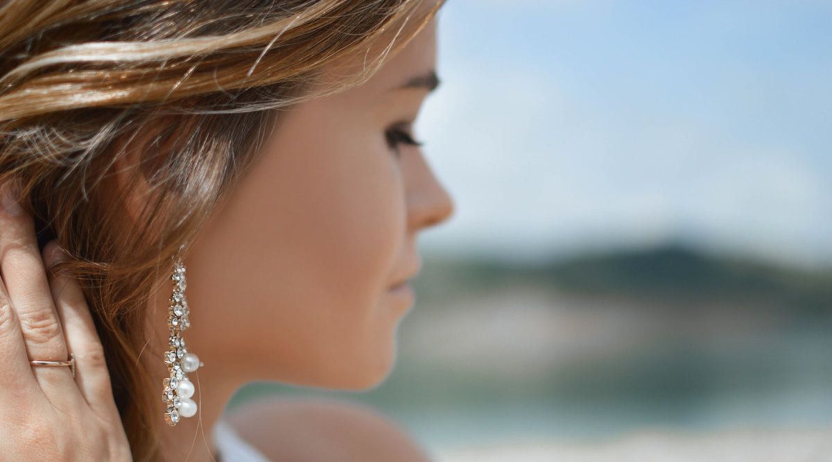 selective focus of woman's face wearing swarovski drop earrings