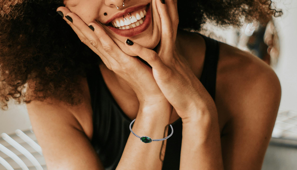 smiling curly haired woman wearing CeriJewelry's B7121 Peridot Swarovski Elements Crystal Cuff Bracelet