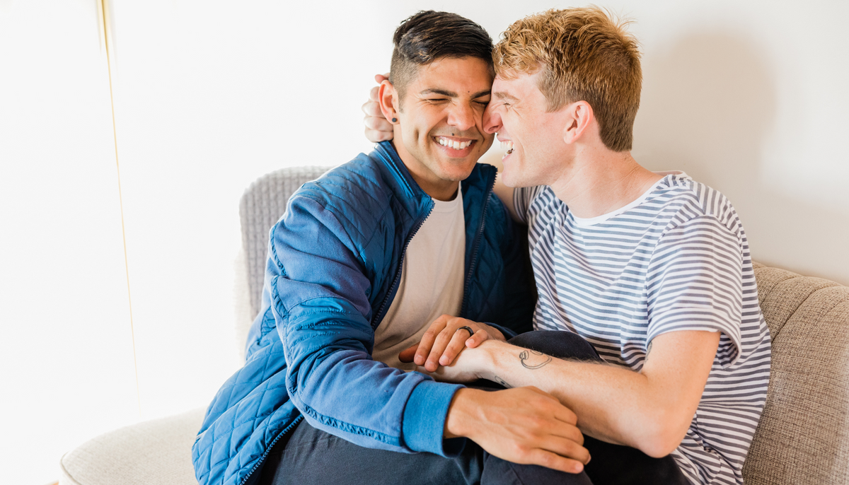 smiling lgbtq couple snuggling on the couch