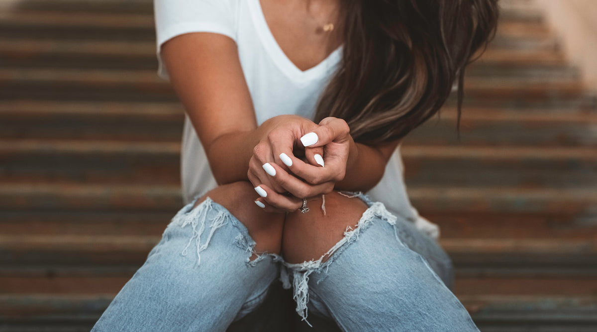 woman with white nail polish wearing fashion ring