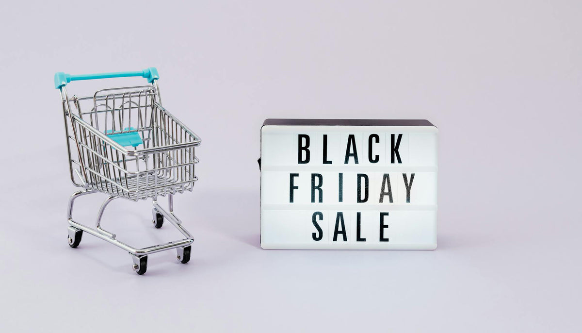 black friday sale sign with a small cart on white surface