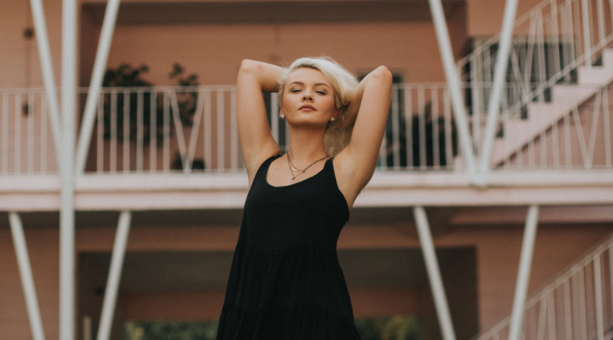 blonde woman wearing a sleeveless little black dress and some fashion jewelry
