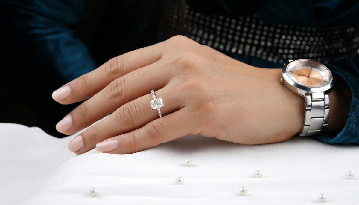 close up shot of woman's hand wearing a solitaire fashion ring and a watch
