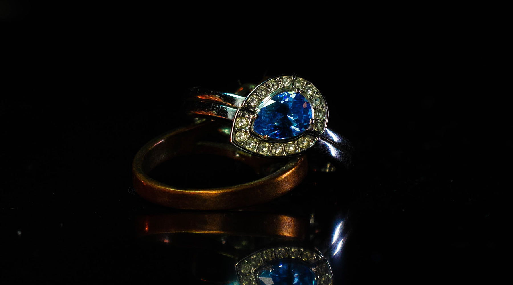 sapphire blue crystal fashion ring on dark surface against dark background