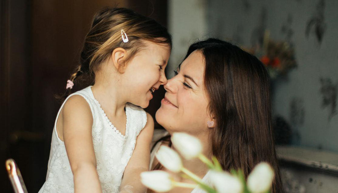 nose-to-nose kiss of a little girl and her mom wearing a Swarovski Elements Heart earrings