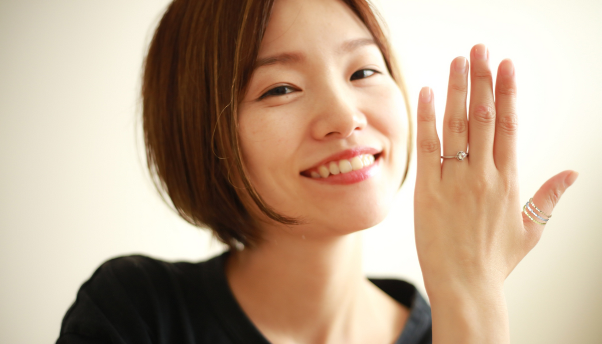 smiling asian woman with a bob showing off her engagement ring and CJE3180 Wholesale Women's Stainless Steel IP Gold & IP Rose Gold Stackable Rings