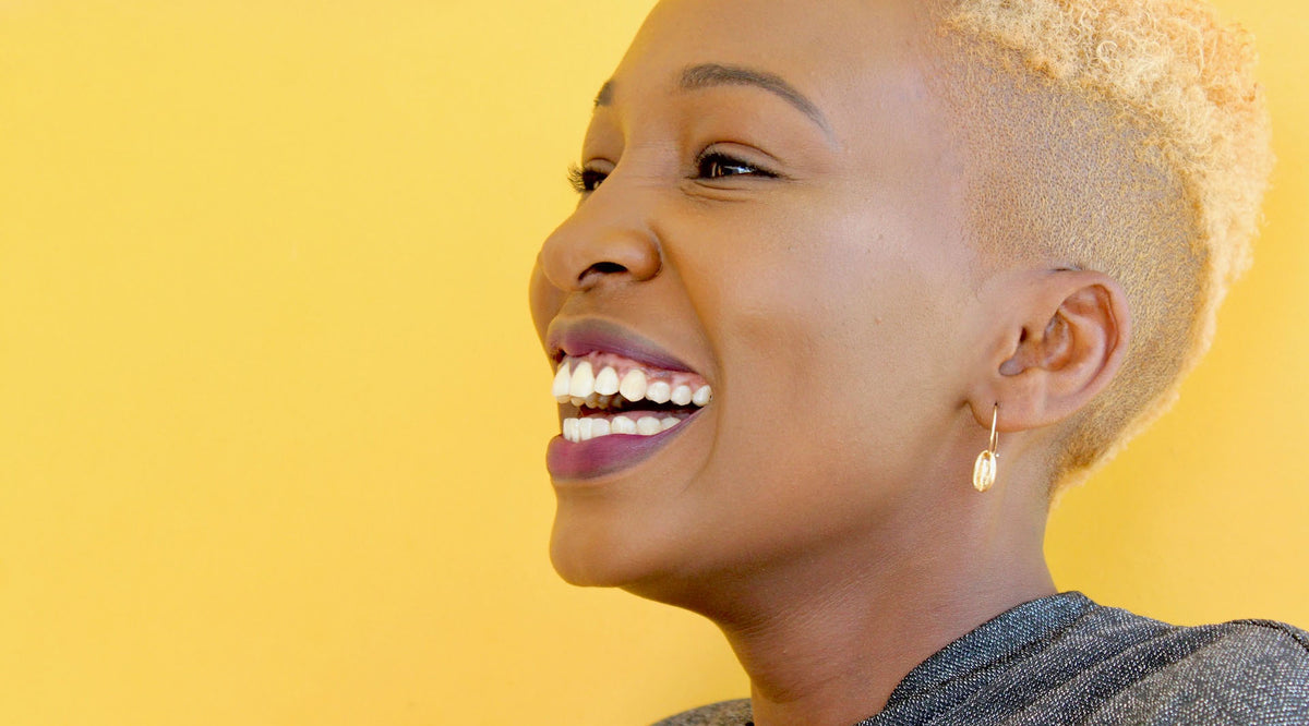 smiling short-haired woman wearing minimalist fashion earrings