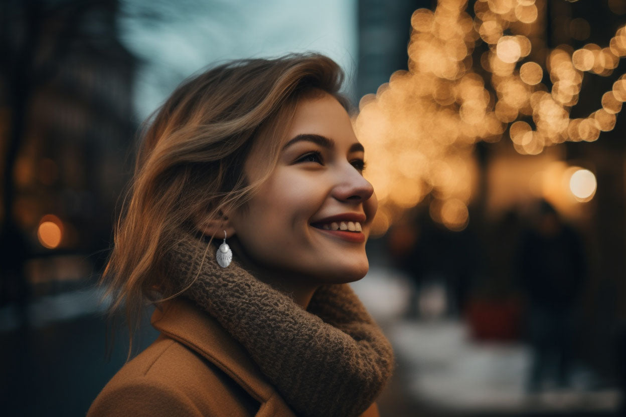 smiling short haired woman wearing CeriJewelry's pearl fashion earrings in winter