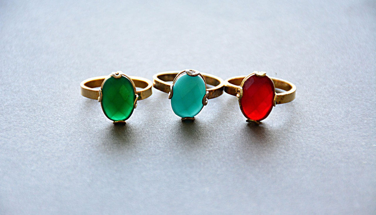 three crystal fashion rings on a white surface