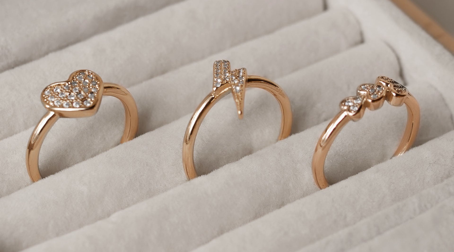 three gold-plated fashion rings in a jewelry box