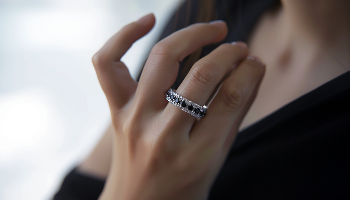 woman's hand wearing a black diamond cz fashion ring and a black top