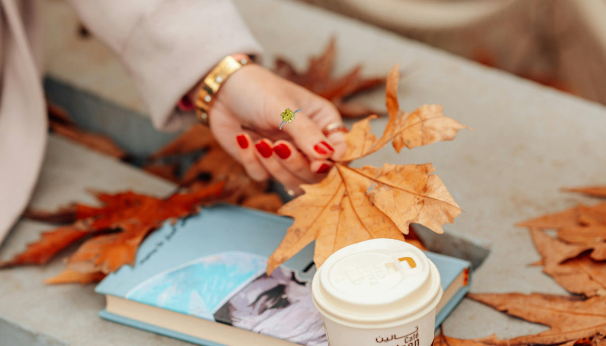 woman's hand with red nails holding an orange leaf and wearing 925 Sterling Silver Rhodium Cubic Topaz Square Ring from CeriJewelry